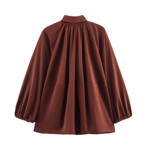 Detail view of deep brown oversized bomber jacket with pleated collar and lantern sleeves