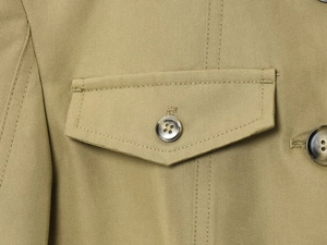Detail of khaki twill jacket showing reinforced cargo pocket with brown resin button closure