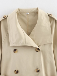 Détails d'un trench-coat kaki avec revers larges, boutons croisés et pattes d'épaule classiques