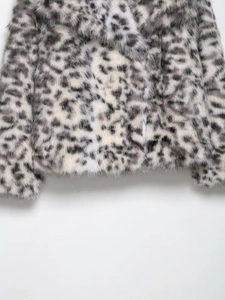 Close-up of soft snow leopard print faux fur jacket showing plush texture and grey patterns