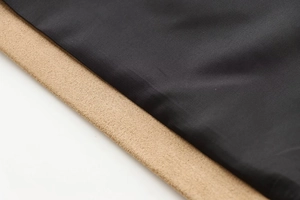 Gros plan d'un tissu texturé noir sur une matière en daim synthétique marron chameau