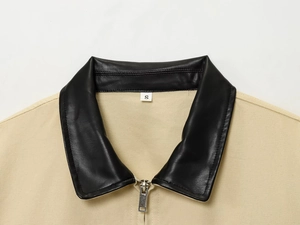 Vue détaillée d'une veste en toile kaki avec col en similicuir noir et zip métallique