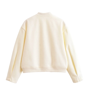 Detail view of the ribbed cuffs and hem on an off-white bomber jacket back