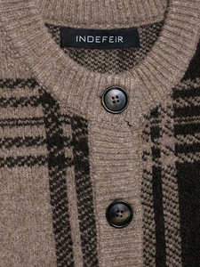 Gros plan sur le col d'un gilet en maille à carreaux avec boutons et texture laine