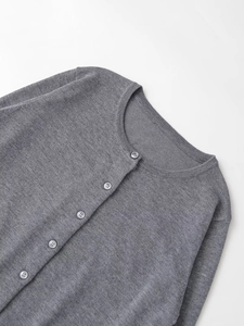 Detail of round neckline and buttons on a grey knit cardigan with fine texture