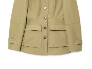 Detail of olive utility jacket featuring 4-button closure and symmetrical flap pockets