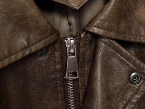 Close-up of deep brown PU leather jacket featuring classic lapels and silver metal zipper