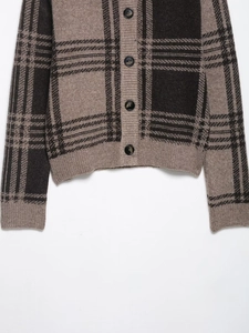 Détail du cardigan en maille à carreaux marron et noir avec boutons et texture côtelée