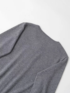 Detail of grey crewneck knit sweater showing fine texture and ribbed neckline finish