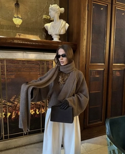 Detail of premium brown chunky knit oversized sweater with matching scarf and elegant texture