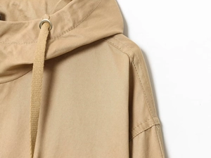 Detail view of khaki hooded jacket shoulder with sturdy seams and premium drawstrings