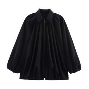 Close-up of black oversized puff jacket showing pleated fabric and metal zipper detail