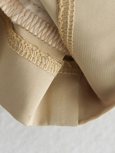 Vue macro de la couture et du tissu sergé résistant sur le trench-coat beige clair