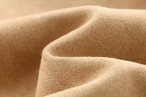 Vue macro de la texture du tissu en suédine douce avec une finition polaire crème