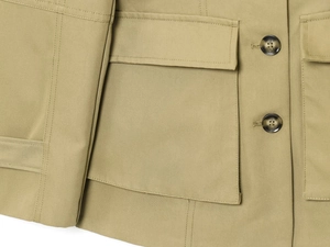 Close-up of khaki jacket featuring tortoiseshell buttons and dual-stitch pocket detail