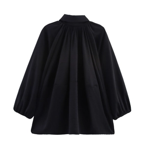 Detailed view of high-neck pleated black blouse with puffy lantern sleeves and loose fit