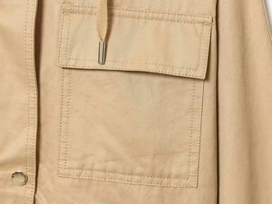 Detailed macro view of khaki cotton hooded jacket with cargo pocket and metal snap button