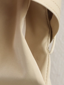 Détail de la boucle de taille d'un trench-coat kaki et texture du tissu en sergé de coton