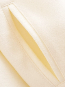 Detail shot of heavy wool cream flight jacket featuring precision diagonal pocket stitching