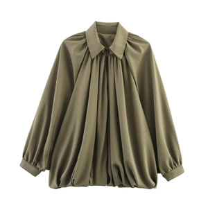 Detailed view of dark green puff sleeve jacket with pleated texture and front zipper