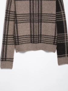 Détail du cardigan en maille à carreaux marron et noir avec poignets et ourlet côtelés