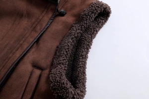 Detailansicht der braunen Wildleder-Weste mit Sherpa-Futter und Kunstleder-Paspelierung