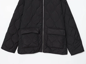 Detail view of the black onion quilted jacket featuring a metal zipper and large flap pockets