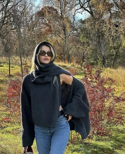 Detail of dark charcoal grey hooded scarf and loose knit cardigan sweater for winter