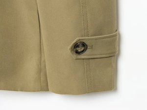 Detailed close-up of khaki jacket cuff with high-density twill fabric and resin button