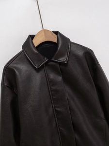Detail shot of vintage dark brown faux leather jacket with high-quality pebble texture