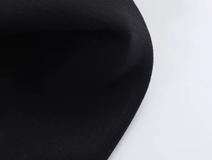 Gros plan du col en maille noire montrant le tissage serré et la texture douce du coton