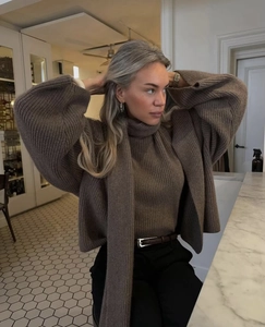 Close-up of brown knit texture on three-piece cardigan, sweater, and scarf set