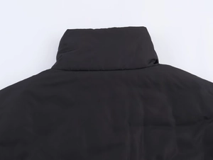Vue détaillée du col montant coupe-vent sur une veste matelassée en tissu dense