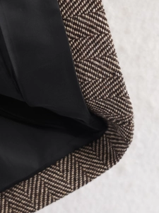 Close-up of brown herringbone wool blazer fabric with premium black silk lining finish