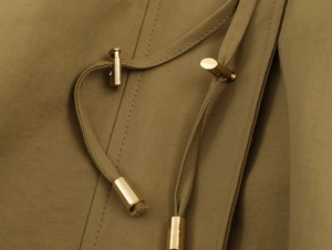 Detailed close-up of khaki jacket drawstring with premium gold metal cord locks