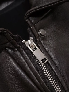 Detail of premium black faux leather texture with silver metal zipper and collar button