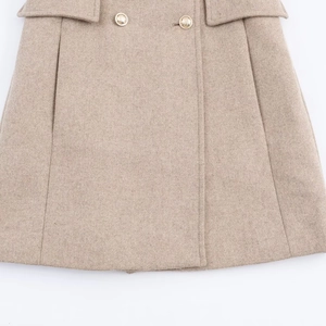 Detailed macro shot of beige woolen coat hem featuring golden buttons and flap pockets