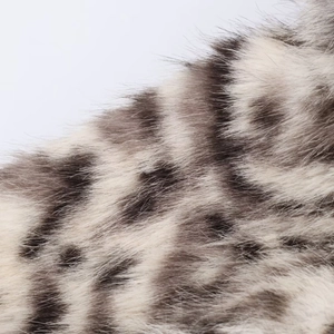 Dettaglio ravvicinato della pelliccia sintetica leopardata con texture morbida e densa