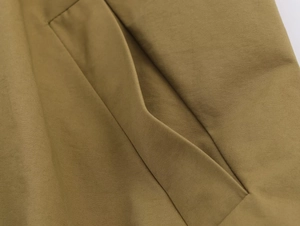 Macro shot of khaki bomber jacket side pocket showing stitching and high-density fabric