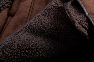 Nahaufnahme der Winterjacke aus Wildlederimitat mit dickem braunem Lammfellfutter und Nähten