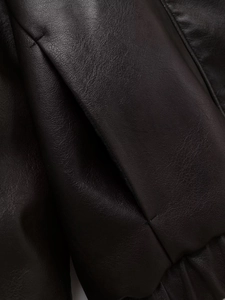 Macro detail of high-quality black faux leather texture with precise stitching and grain
