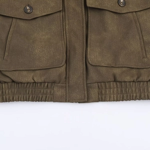 Détail de veste en suédine avec grandes poches utilitaires et fermeture à boutons
