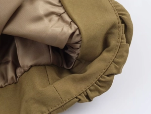Close-up of khaki bomber jacket featuring smooth satin lining and elastic hem stitching