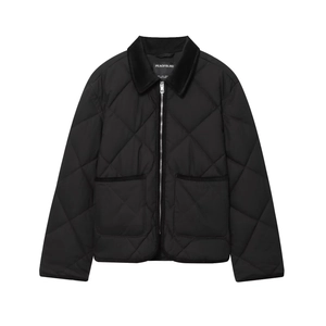 Détail d'une veste matelassée noire avec col en velours côtelé et zip métallique