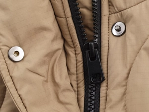 Détail de la veste imperméable kaki avec texture ripstop, fermeture éclair et boutons