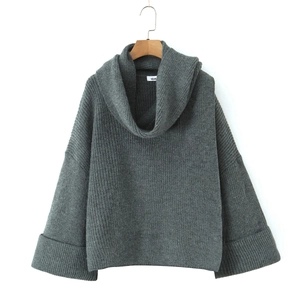 Detail of grey oversized knit sweater featuring a thick turtleneck and ribbed cuffs