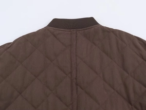 Detail view of brown quilted bomber jacket with ribbed collar and diamond stitch pattern