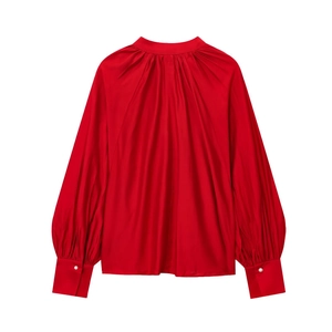 Detail view of red satin shirt with lantern sleeves and elegant pearl button cuffs