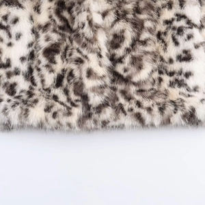 Dettaglio della morbida ecopelliccia leopardata con macchie marroni su tessuto felpato