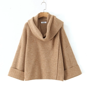 Detail of chunky brown knit sweater featuring oversized cowl neck and textured fabric